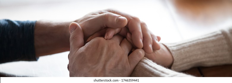 Middle-aged Couple Sit Indoors Holding Hands Close Up Photo. Spouses Feeling Connection And Love, Share Problems Express Empathy Showing Compassion Concept. Horizontal Banner For Website Header Design