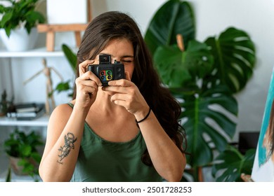 Middle-aged female artist taking a photo with an old film camera - Powered by Shutterstock