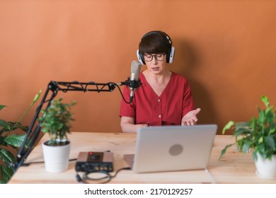 Middle-aged Female Radio Presenter Talking Into The Microphone And Reading News - Radio Broadcast Online Concept