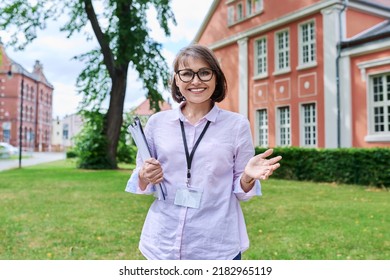 Middle-aged female school worker, teacher on background of school building - Shutterstock ID 2182965119