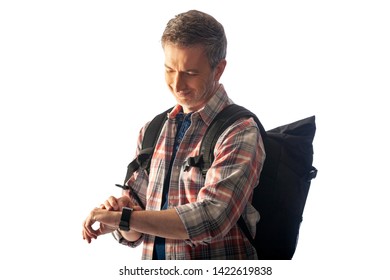 Middle-aged hiker checking heart rate pulse with health apps on a smartwatch.  He is lit with sunset light to blend with commposite backgrounds. - Powered by Shutterstock