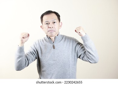 Middle-aged Japanese man in gray turtleneck wool sweater under white background. Concept image of Warm Biz, stability in daily life, and sustainable living. - Shutterstock ID 2230242655