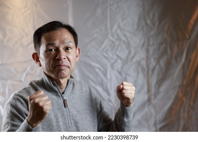 Middle-aged Japanese man in gray turtleneck wool sweater. Concept image of Warm Biz, stability in daily life, and sustainable living. - Shutterstock ID 2230398739