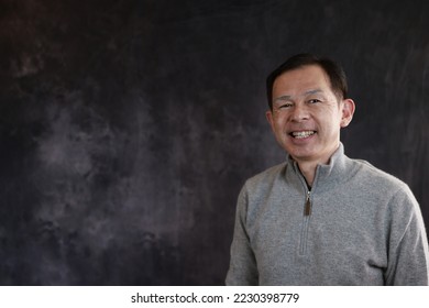 Middle-aged Japanese man in gray turtleneck wool sweater. Concept image of Warm Biz, stability in daily life, and sustainable living. - Shutterstock ID 2230398779