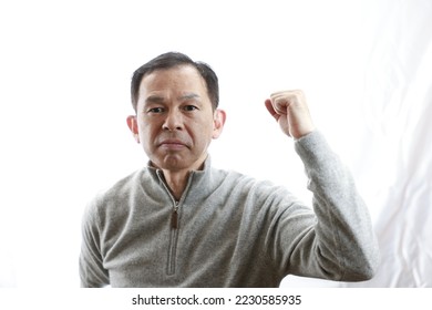 Middle-aged Japanese man in gray turtleneck wool sweater. Concept image of Warm Biz, stability in daily life, and sustainable living. - Shutterstock ID 2230585935