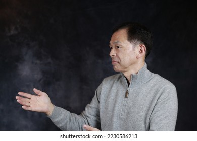 Middle-aged Japanese man in gray turtleneck wool sweater. Concept image of Warm Biz, stability in daily life, and sustainable living. - Shutterstock ID 2230586213
