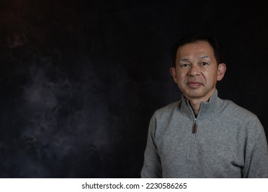 Middle-aged Japanese man in gray turtleneck wool sweater. Concept image of Warm Biz, stability in daily life, and sustainable living. - Shutterstock ID 2230586265