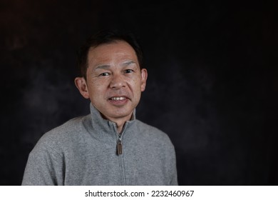 Middle-aged Japanese man in gray turtleneck wool sweater. Concept image of Warm Biz, stability in daily life, and sustainable living. - Powered by Shutterstock