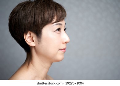 Middle-aged Japanese woman looking sideways and smiling