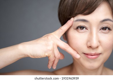 A middle-aged Japanese woman who smoothes out wrinkles on the corners of the eyes and mouth