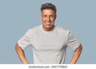 Middle-aged Latino man confident keeping hands on hips. - Powered by Shutterstock