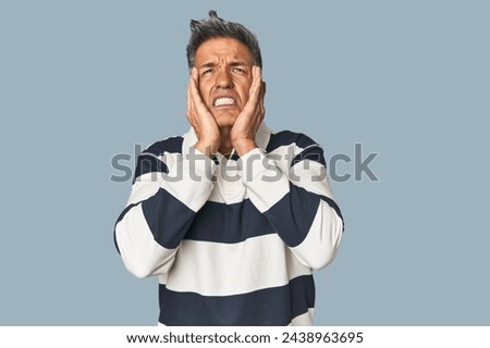 Middle-aged Latino man whining and crying disconsolately.