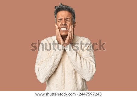 Middle-aged Latino man whining and crying disconsolately.