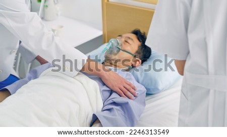 A middle-aged male patient in a coma in a hospital bed.