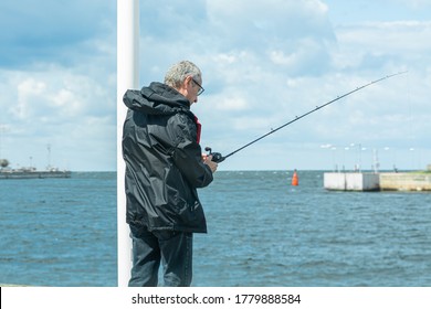 A Middle-aged Man, 50 Plus, With A Fishing Rod. Fishing Is One Of The Safe Activities During The Coronavirus Pandemic. It Is An Outdoor Activity And It Includes Social Distance