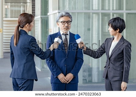 A middle-aged man being interviewed by the media