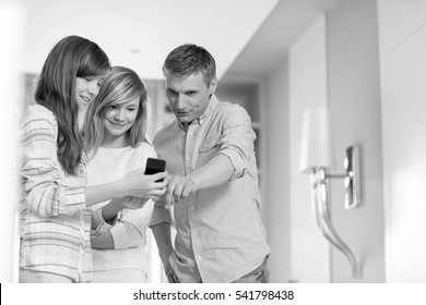 Middle-aged man with daughters using smart phone at home