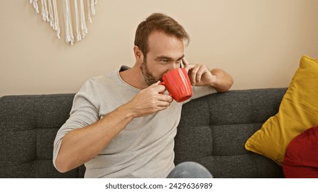 Middle-aged man drinking coffee while talking on the phone indoors. - Powered by Shutterstock