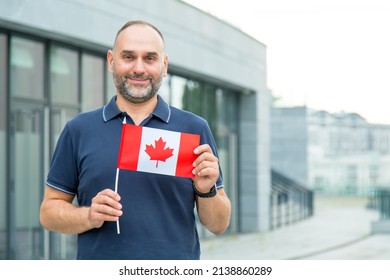 Middle-aged man with the flag of Canada on the background of the city.