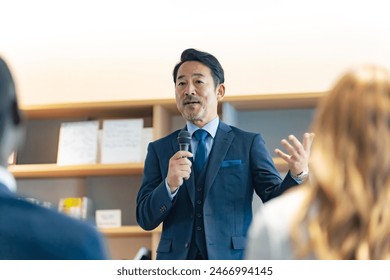 A middle-aged man giving a speech in the lobby - Powered by Shutterstock