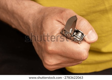 Middle-aged man hand holding sharp pocketknife, concept of violence, assault, murder, force, abuse, and domestic violence.