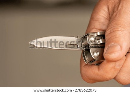 Middle-aged man hand holding sharp pocketknife, concept of violence, assault, murder, force, abuse, and domestic violence.