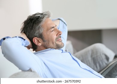 Middle-aged man having a restful moment relaxing in sofa - Powered by Shutterstock