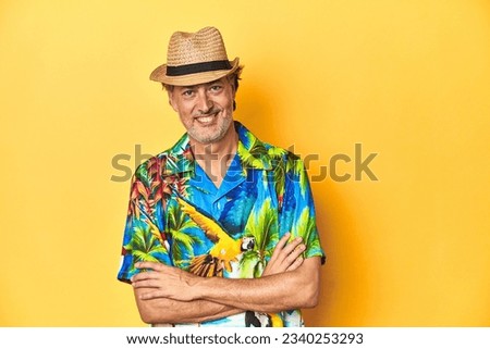 Middle-aged man in Hawaiian shirt and straw hat Middle-aged man in Hawaiian shirt and straw hatlaughing and having fun.
