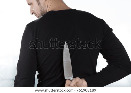A middle-aged man with a knife behind his back. Domestic violence. The murderer in the house. Desire to avenge. Betrayal. Rage with a knife in his hand.