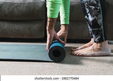 Middle-aged Man Picks Up A Yoga Mat At Home.
New Normal Concept, Exercising At Home