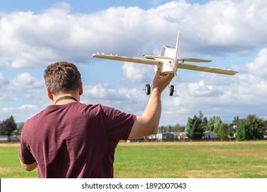 Middle-aged man piloting a model of the radio remote controlled airplane outdoor on a background of the sky
