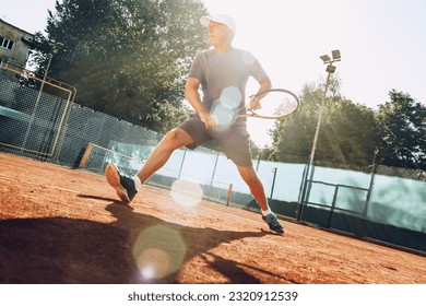 Middle-aged man playing tennis on outdoor tennis filed - Powered by Shutterstock