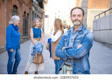 middle-aged man posing for camera with his group of friends behind him