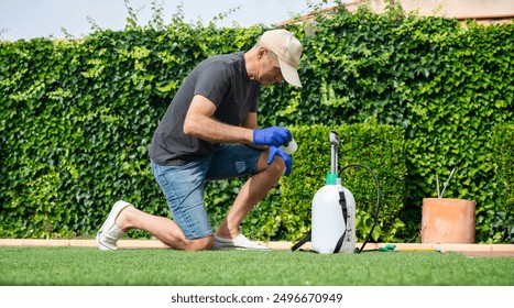 Middle-aged man preparing fumigation equipment in the garden - Powered by Shutterstock