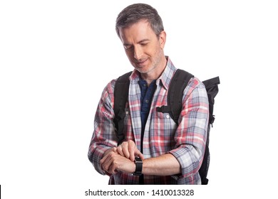 Middle-aged man or senior citizen checking heart rate pulse with health apps on a smartwatch.  He also looks like a hiker checking the wearable technology for gps navigation. - Powered by Shutterstock