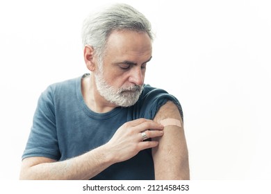 Middle-aged man showing the arm patch after the covid-19 vaccination - immunization concept. High quality photo - Powered by Shutterstock