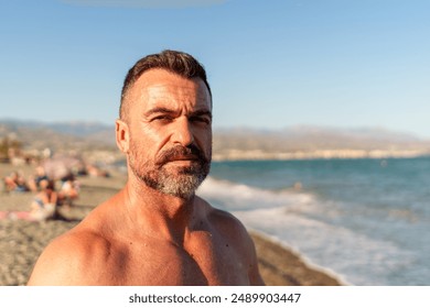 Middle-aged man taking a selfie on the beach with blurred background and copy space - Powered by Shutterstock