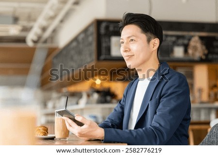 Middle-aged man using a smartphone in a cafe