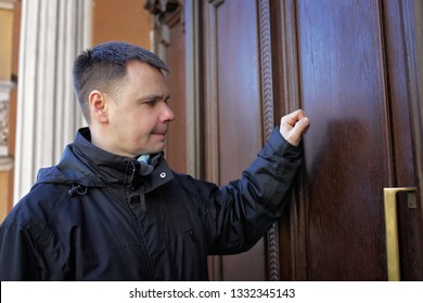 Middle-aged Man Waiting In Front Of Wooden House Door And Thinking To Knock Or Not To Knock, People Relationship, Date And Meeting Concept, Outdoor