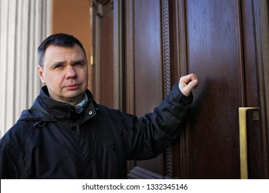 Middle-aged Man Waiting In Front Of Wooden House Door And Thinking To Knock Or Not To Knock, People Relationship, Date And Meeting Concept, Outdoor