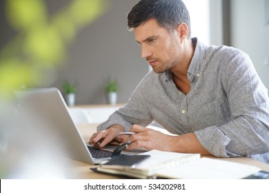 Middle-aged Man Working From Home On Laptop Computer