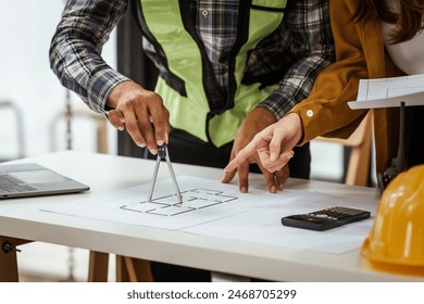 A middle-aged man, a young woman, and other Asian individuals collaborate on architectural engineering for condos and apartments, focusing on sustainable renovation and green energy solutions. - Powered by Shutterstock