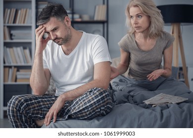Middle-aged married couple having problems and arguing about their relationship in the bedroom - Powered by Shutterstock