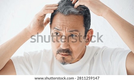 Middle-aged men concerned about their hairline. Hair growth, hair loss, gray hair, men's grooming, cosmetics, middle-aged and older, thinning hair, concerns.