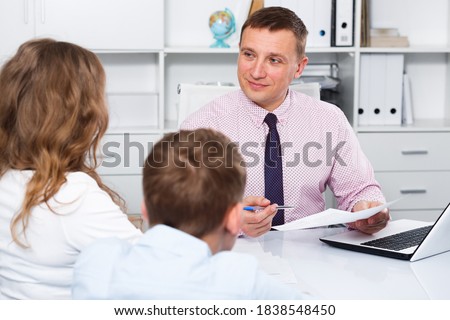 Middle-aged mother and son visiting consultation with school headmaster
