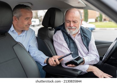middle-aged passenger in back seat paying with mobile app to elderly driver-concept of transportation, cab, taxi and technology