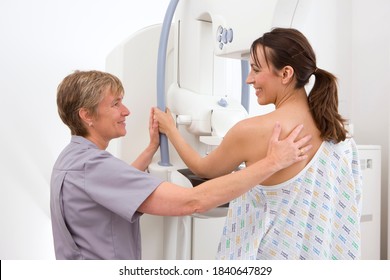 A Middle-aged Radiologist In Uniform Attending An Adult Patient Being On A Mammogram Machine With A Warm Smile