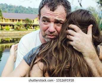 Middle-aged sad man and his daughter teenager girl hugging outdoors. - Powered by Shutterstock