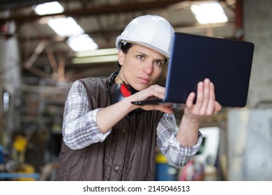 middle-aged superior holding laptop in hands - Shutterstock ID 2145046513