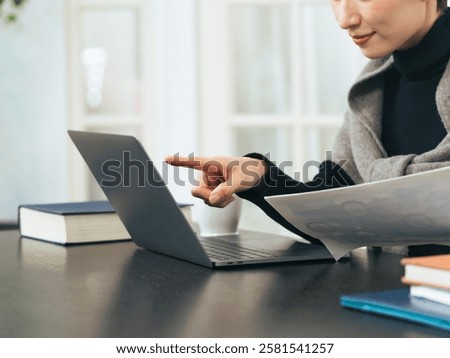 A middle-aged woman checking data on a laptop